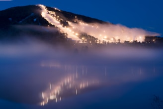 Strange glowing lights hovering over mountain ridges at night.