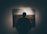 silhouette of man standing in front of painting hanged on wall