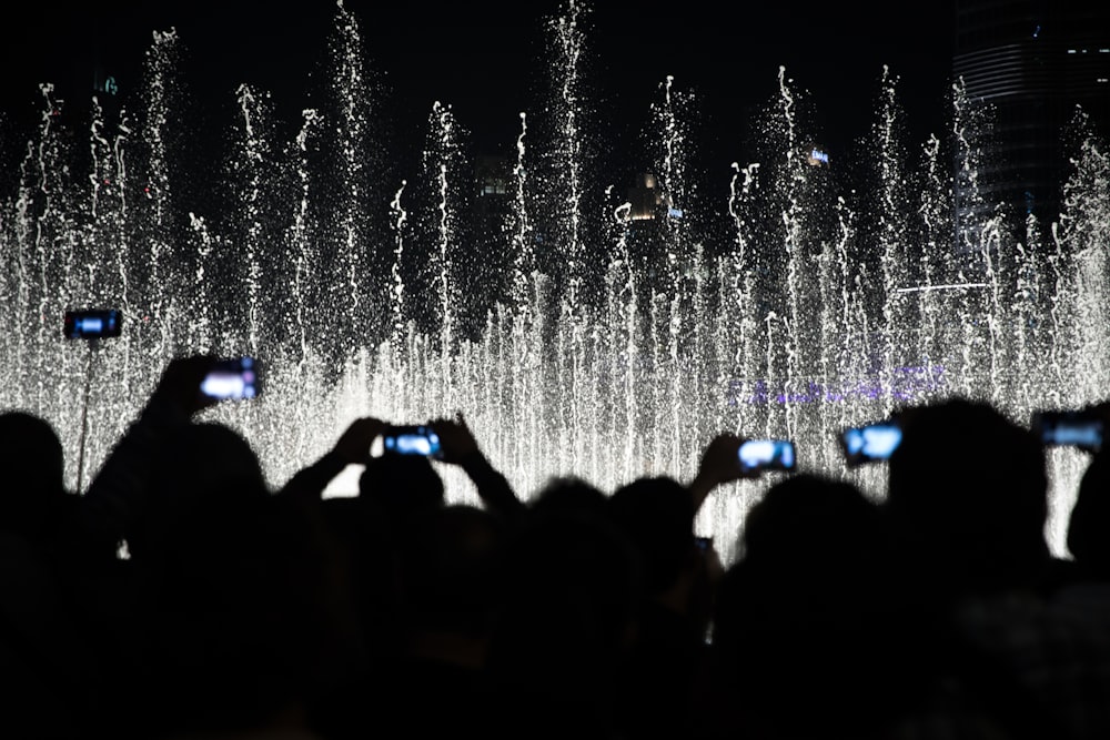 夜の噴水の写真を撮る人々