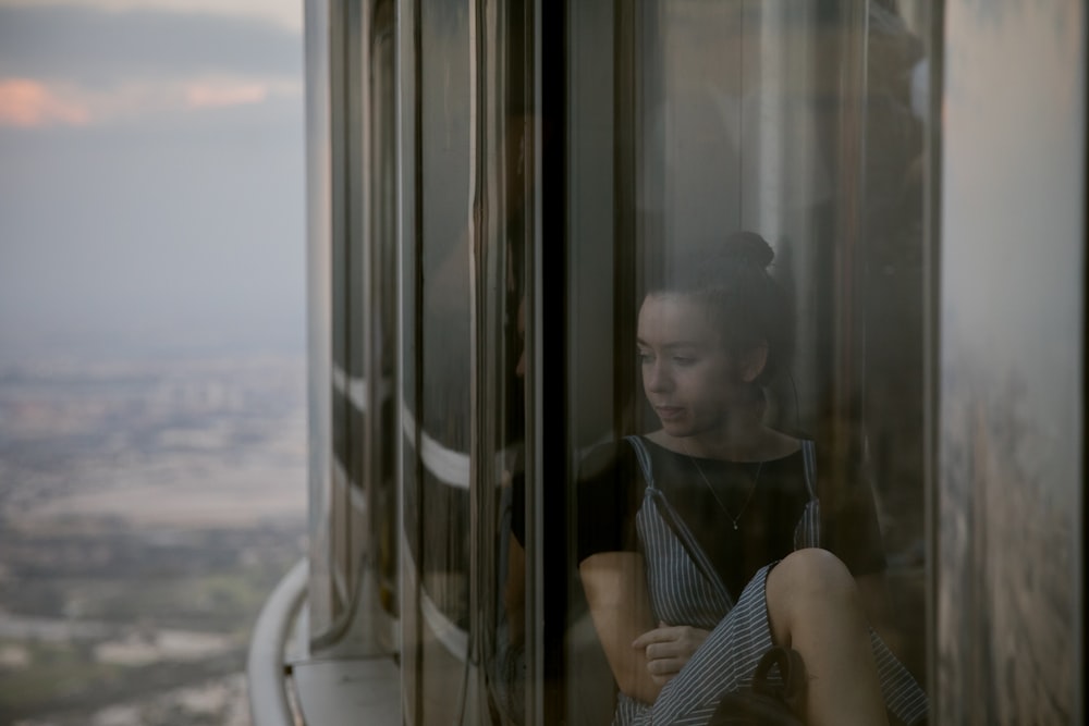 woman in blue spaghetti strap dress sitting inside house