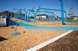 Children playing together on the school’s modern playground under a clear sky.