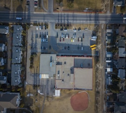 aerial photography of large building with vehicles on parking lot during daytime