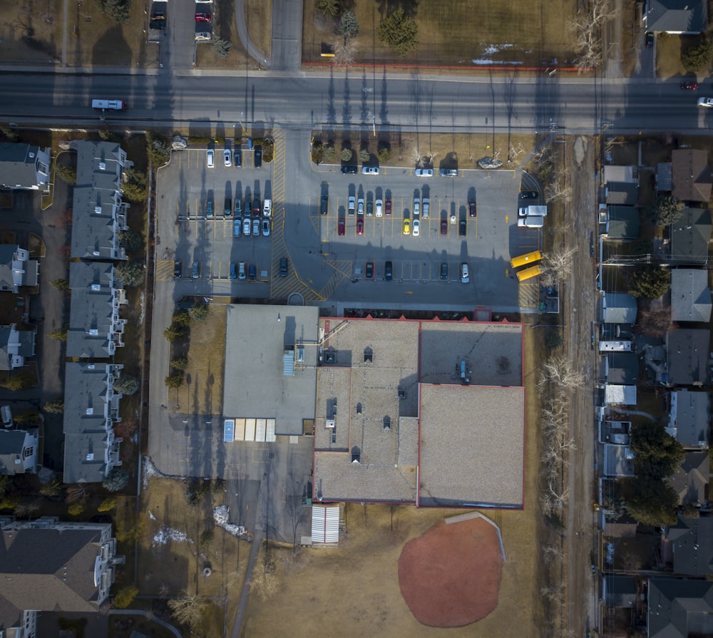 aerial photography of large building with vehicles on parking lot during daytime