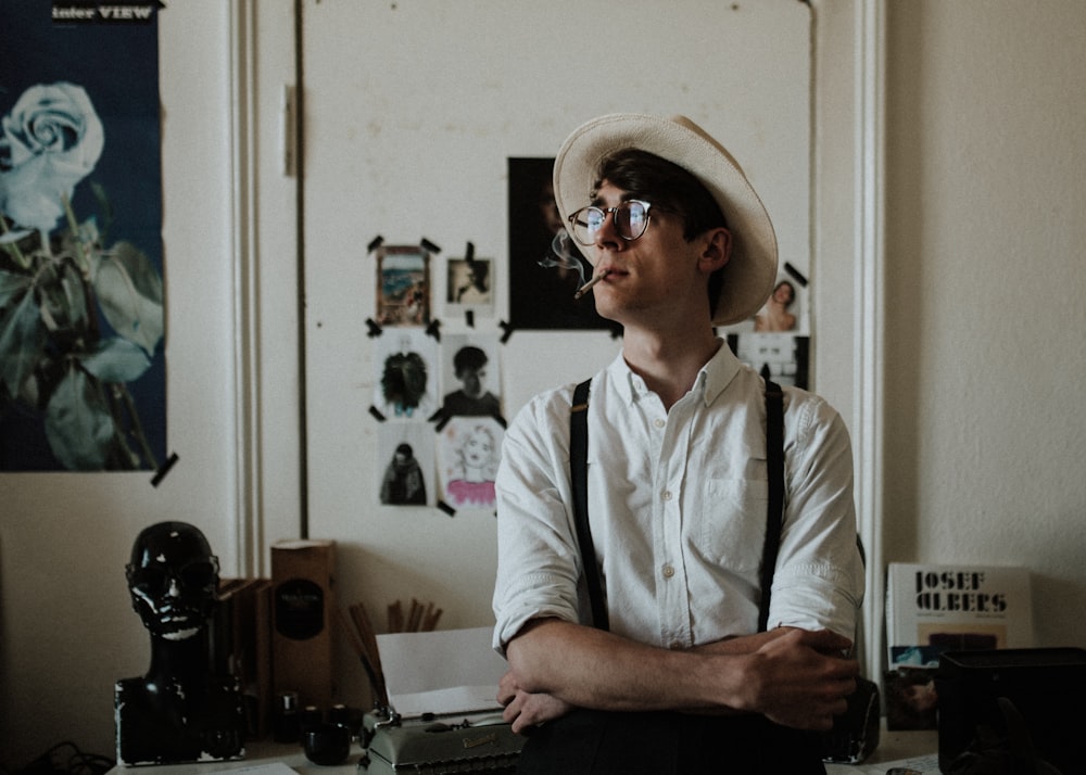 man wearing black suspenders standing behind door