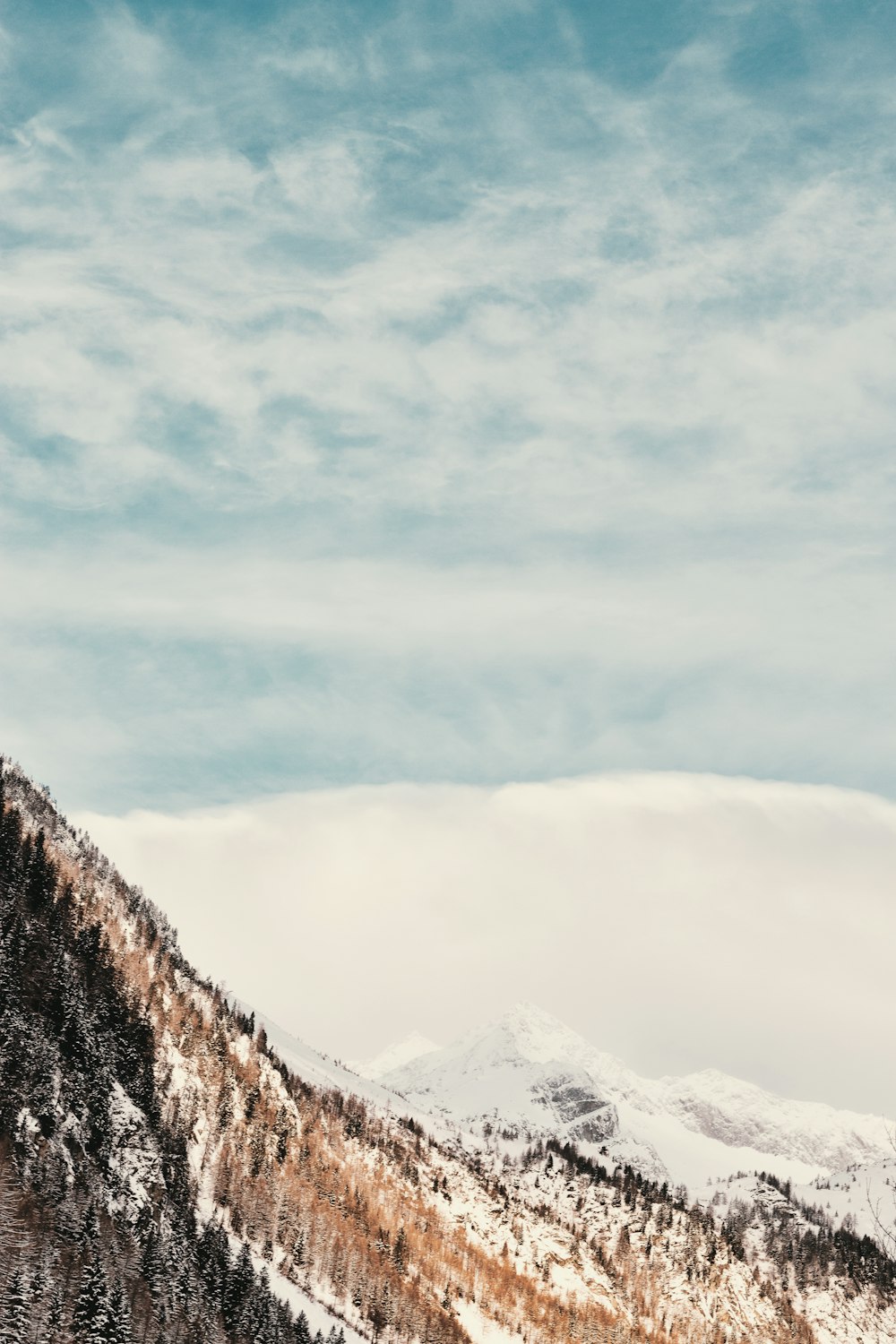 snowy mountain under cloudy sky