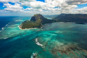 aerial photography of sea near mountain at daytime