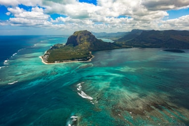 aerial photography of sea near mountain at daytime