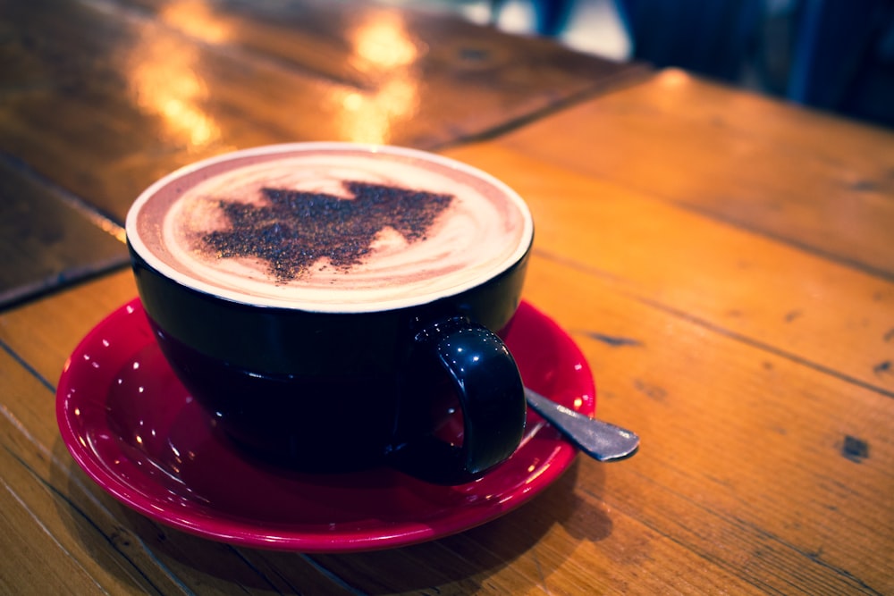 blue cup with cappuccino on red bowl