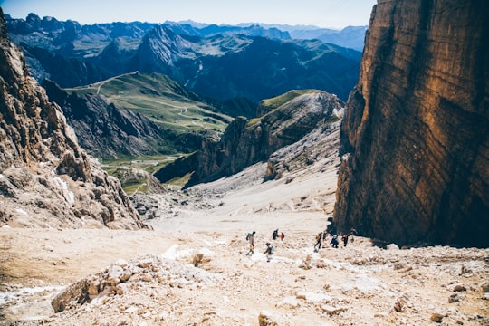 landscape photo of group of person walking on mountain in Pordoi Pass Italy