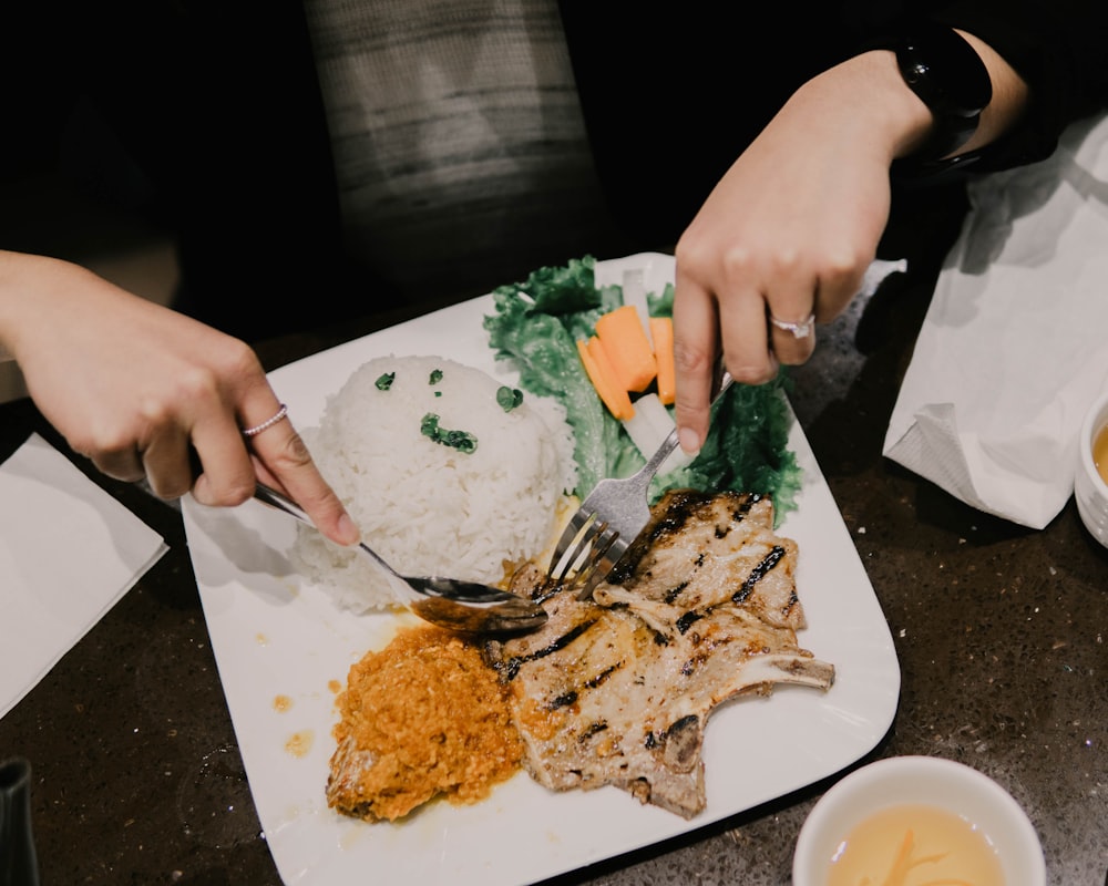 person eating food on white ceramic plate