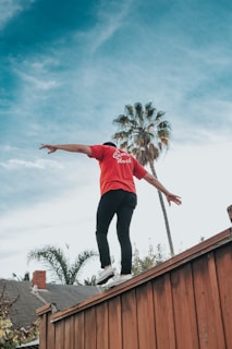 man standing on brown wooden wall during daytime