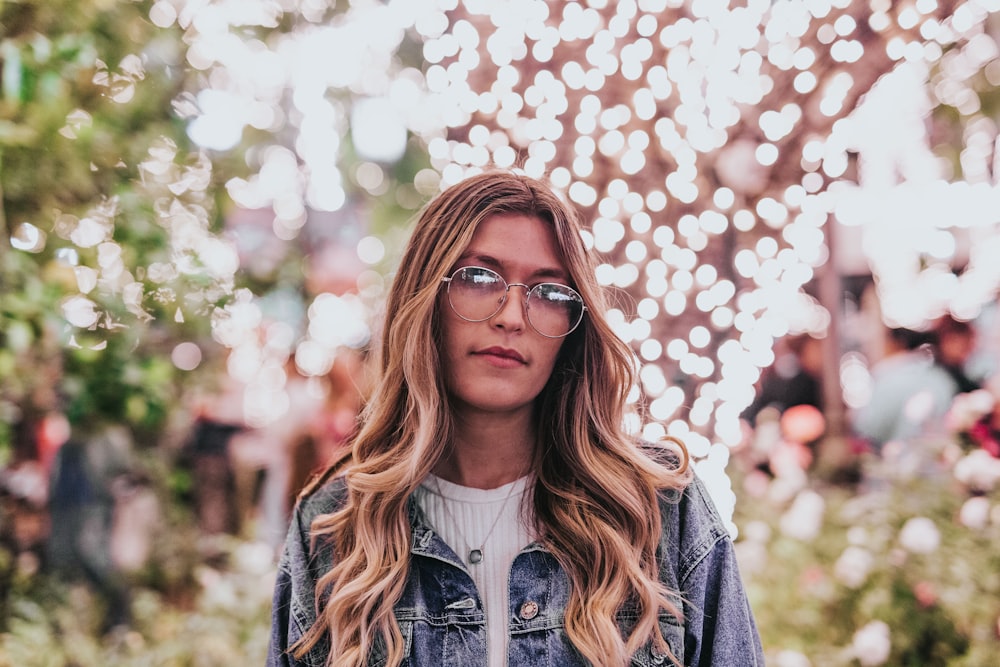 woman wearing blue denim jacket near trees