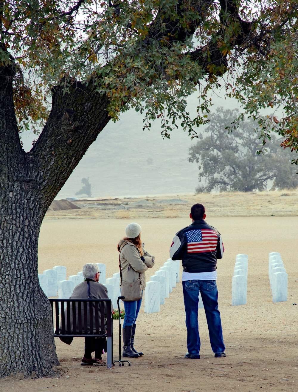 three person in front of armless chairs during daytime