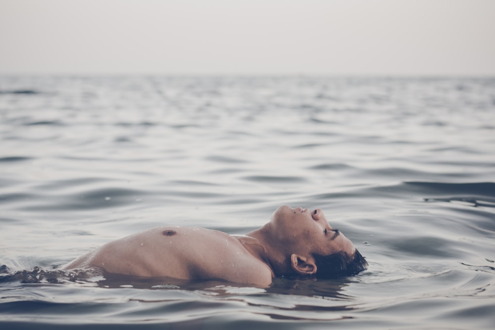 Mann, der tagsüber auf dem Wasser schwimmt