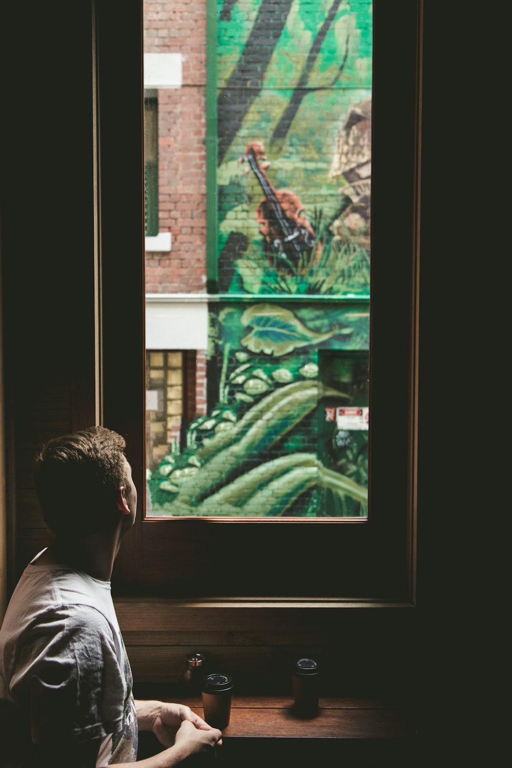 man looking outside window