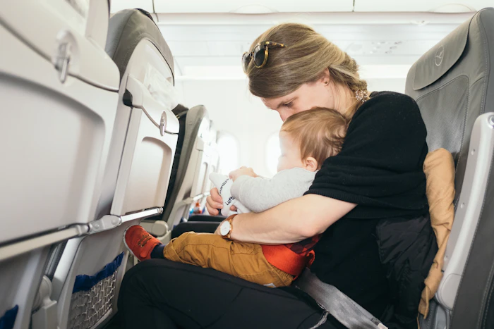 B&eacute;b&eacute; sur les genoux d'un parent dans une cabine d'avion