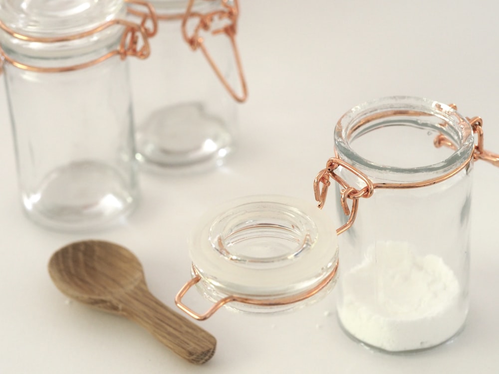 open glass jar near brown wooden spatula