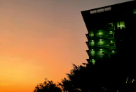 Sunset behind the Brazilian Congress building, bathed in green and yellow lighting.