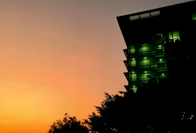 Modern building silhouette at dusk with subtle green highlights.