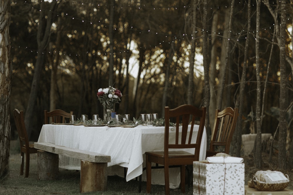 dining table and chairs set in the middle of the woods