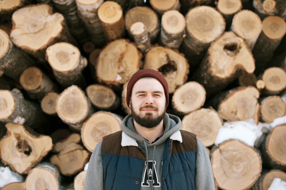 man standing behind firewoods