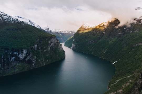 body of water between mountains in Geiranger Norway