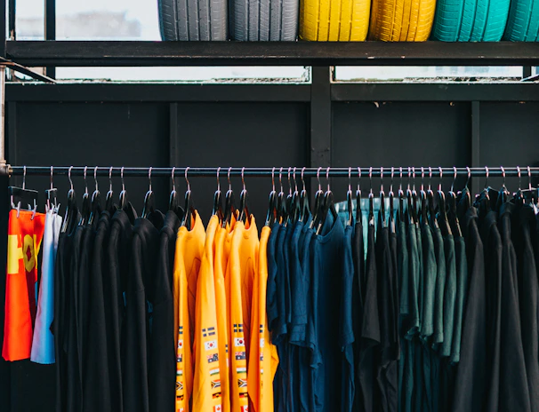assorted-color clothes hanged on rack below six assorted-color ties