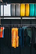 assorted-color clothes hanged on rack below six assorted-color ties