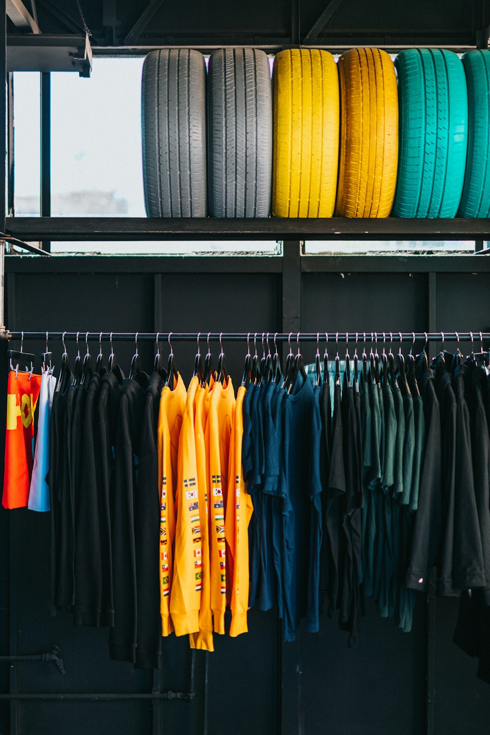 assorted-color clothes hanged on rack below six assorted-color ties