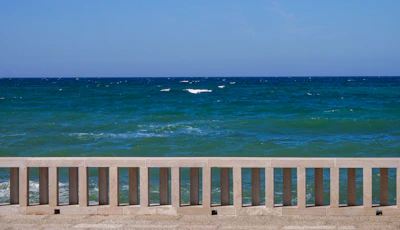 Crystal clear blue sea seen from the Spiaggia di Serapo, framed by sandy shore.