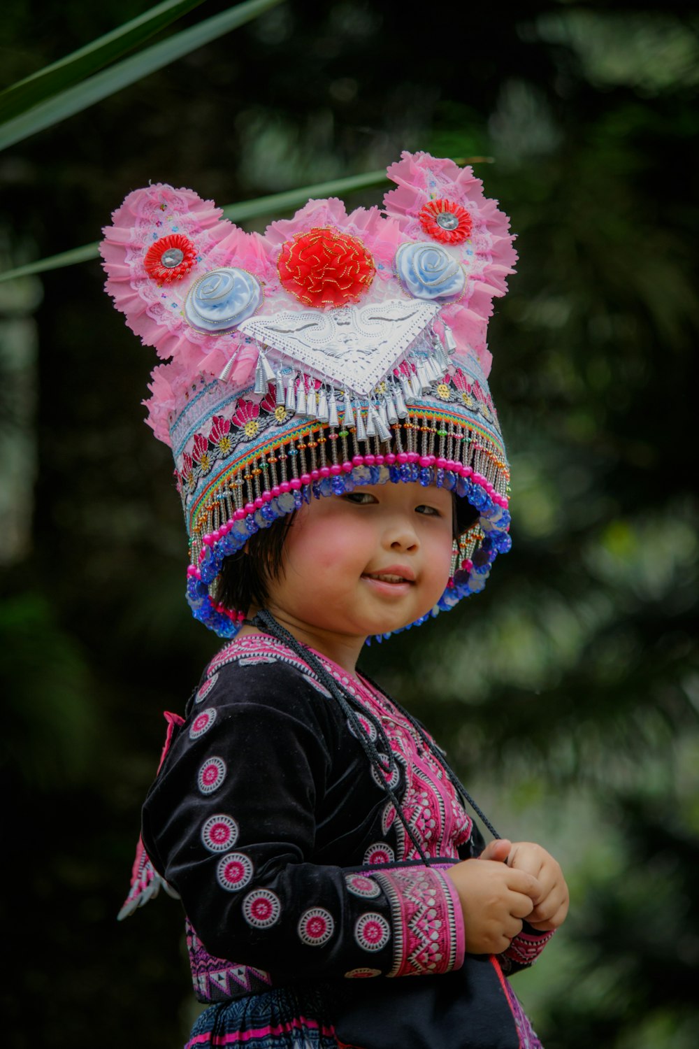 toddler wearing pink and blue beaded tassel hat