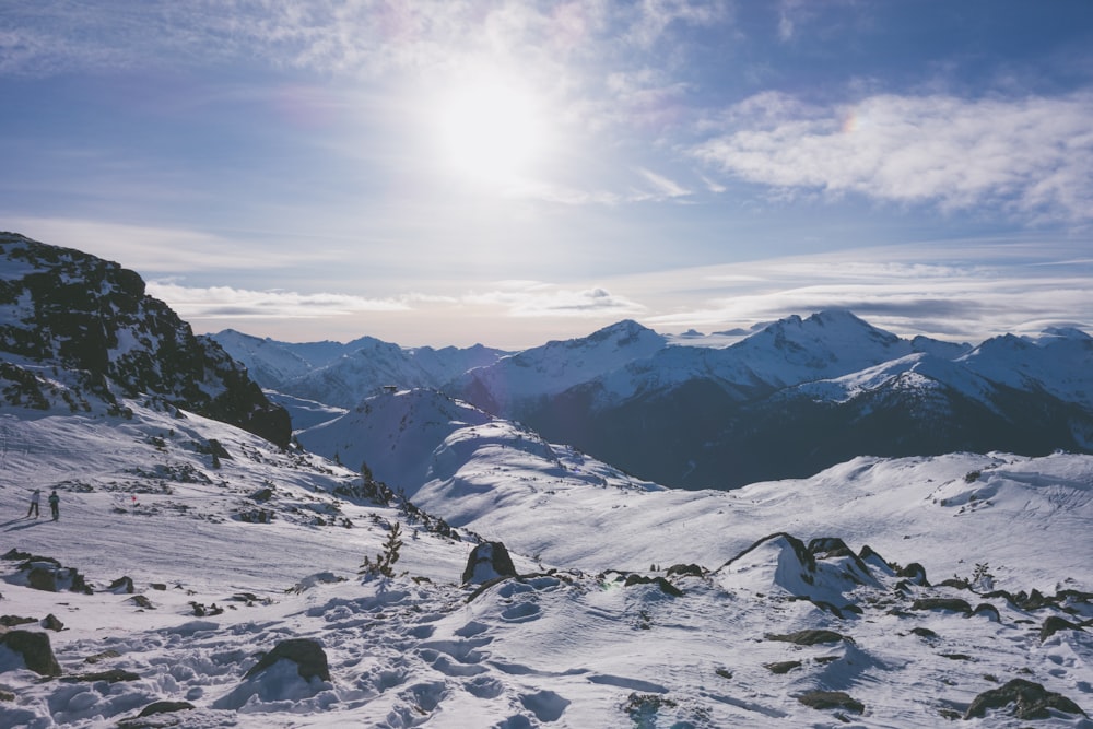 group of people standing on top snowy mountain during daytime