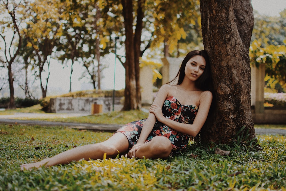 woman leaning on tree during daytime