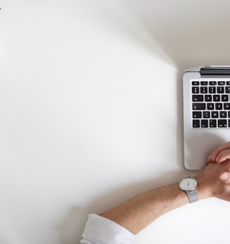 person wearing watch near laptop