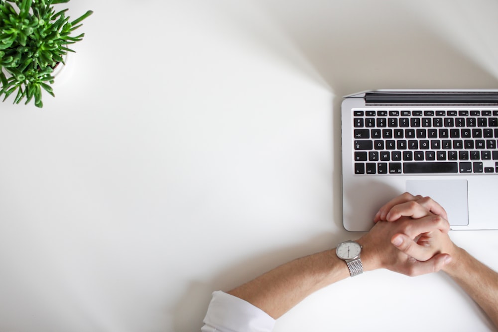 Person, die Uhr in der Nähe des Laptops trägt