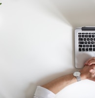 person wearing watch near laptop