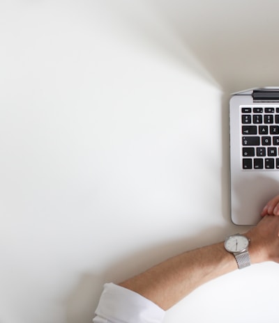 person wearing watch near laptop