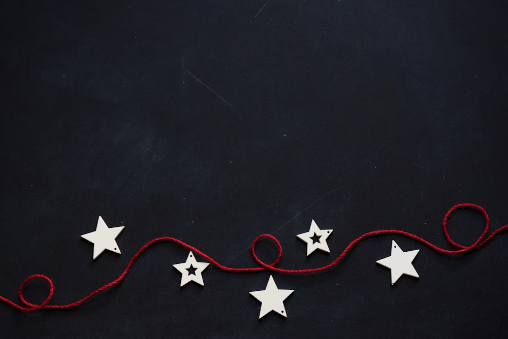 white stars cutout on black surface with red string