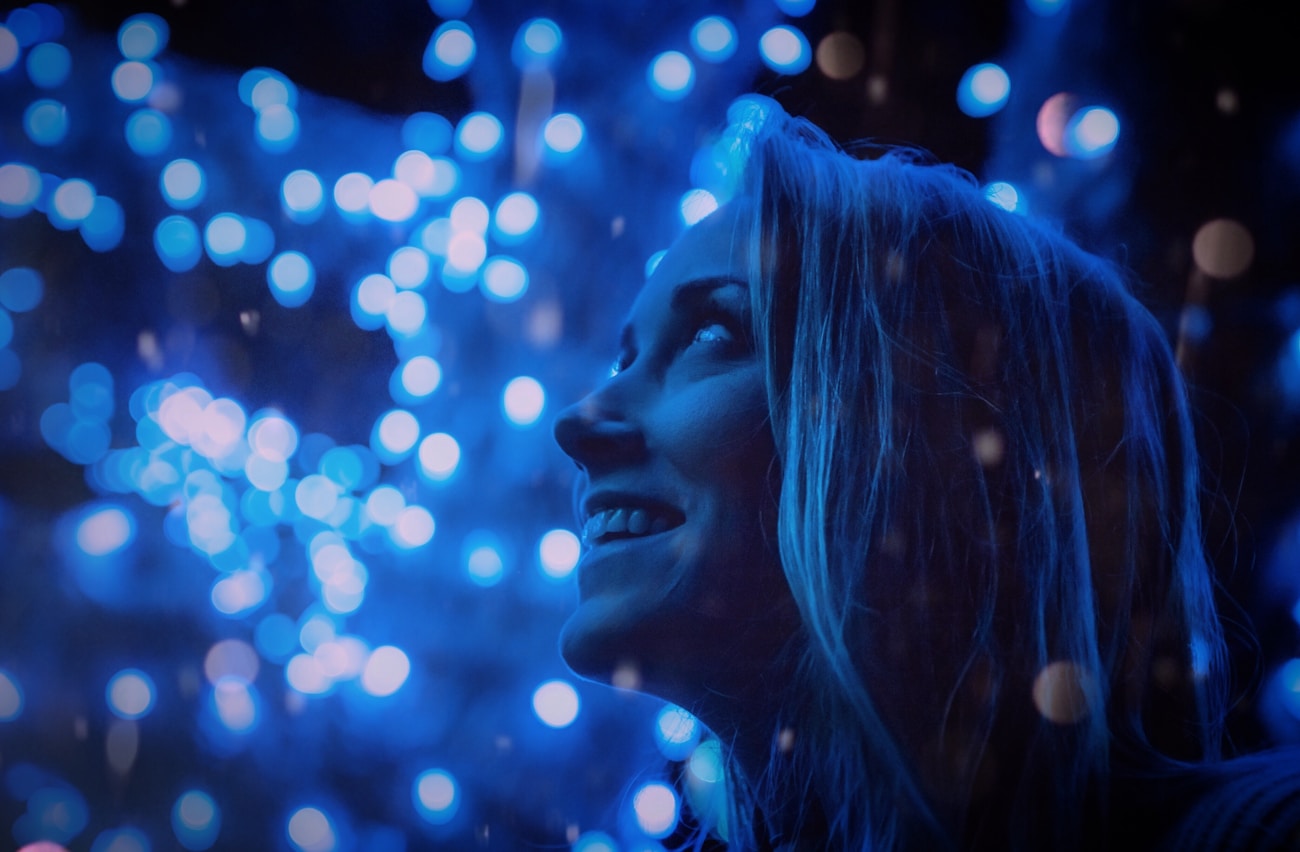 Woman surrounded by warm fairy lights creating a magical bokeh portrait