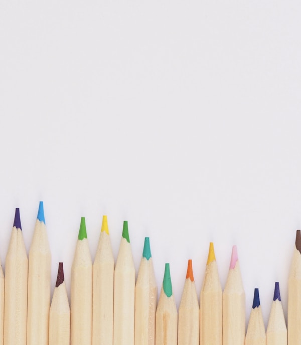 colored pencil lined up on top of white surface