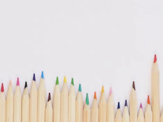 colored pencil lined up on top of white surface
