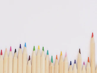 colored pencil lined up on top of white surface