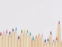 colored pencil lined up on top of white surface