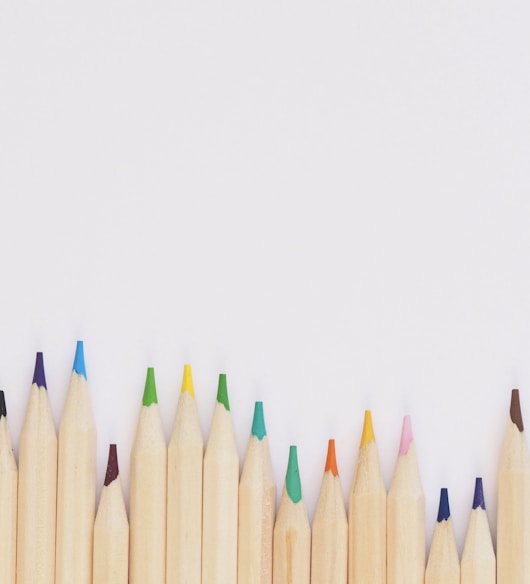 colored pencil lined up on top of white surface