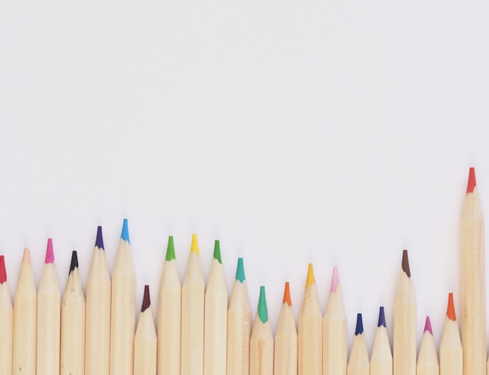 colored pencil lined up on top of white surface