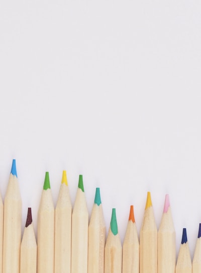 colored pencil lined up on top of white surface