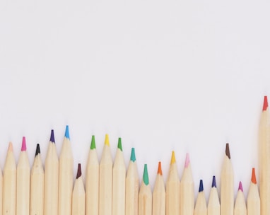 colored pencil lined up on top of white surface