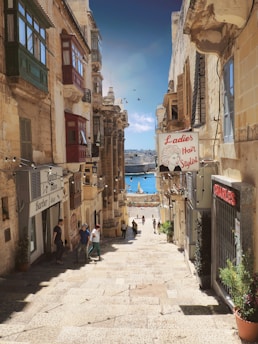 people walking on stairs between buildings in distant of mountain