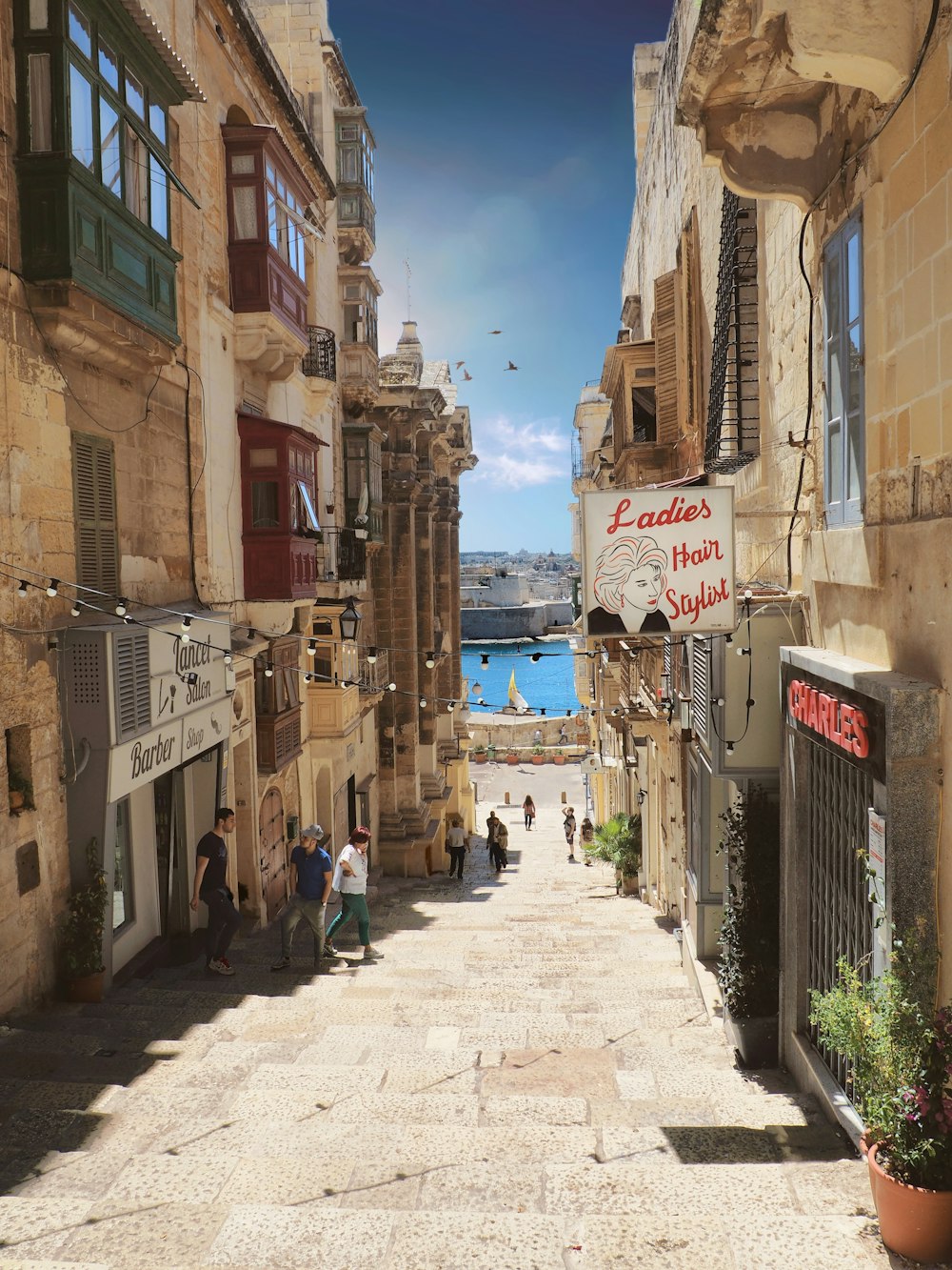 people walking on stairs between buildings in distant of mountain