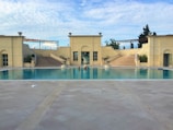 Elegant hardscape application around a villa pool area with beige and stone gray tones.